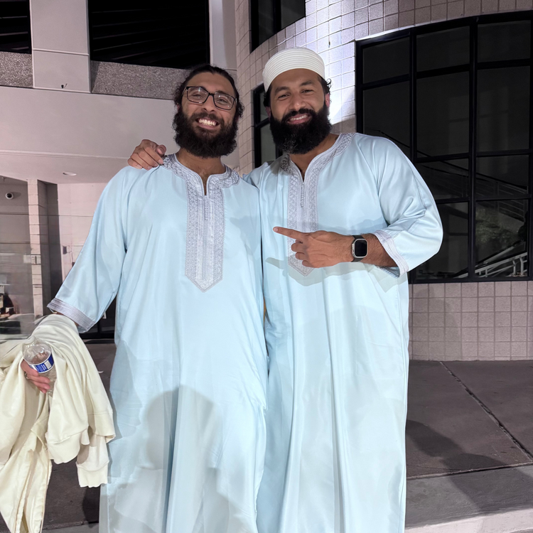 Two men wearing pastel blue embroidered Moroccan thobes