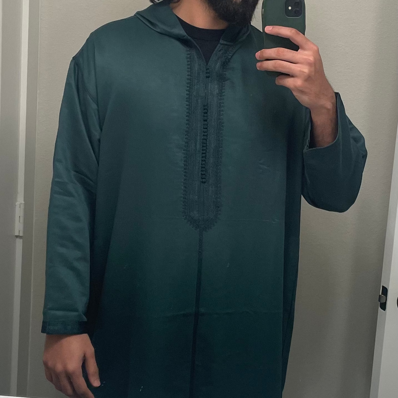 Close up of a dark green Moroccan thobe showing the embroidered placket