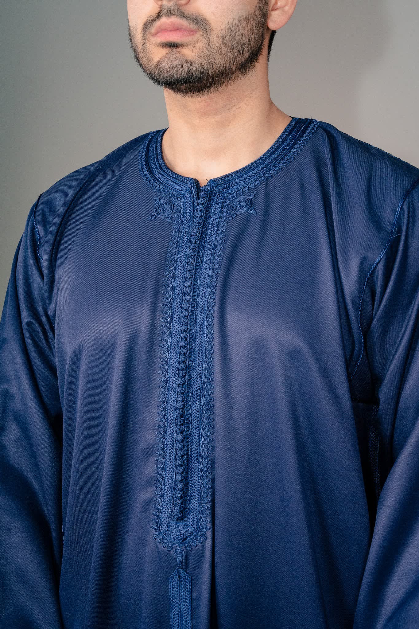 Embroidered placket and concealed zip neck on a deep blue Moroccan kaftan thobe
